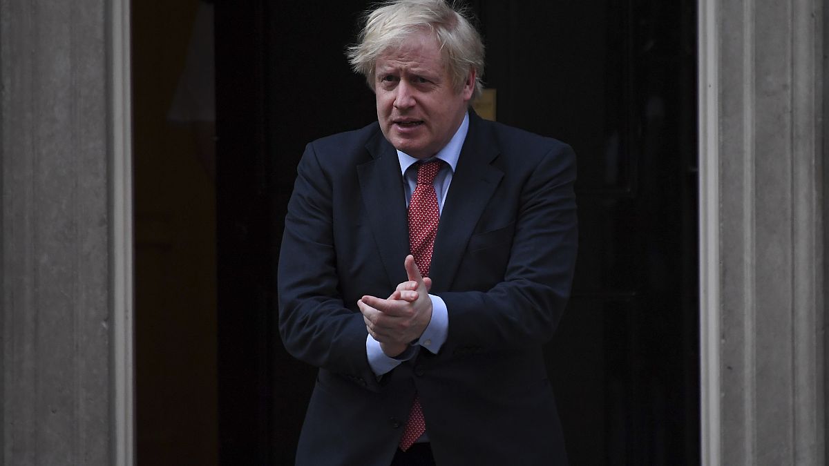 Britain's Prime Minister Boris Johnson joins in the applause on the doorstep of 10 Downing Street in London during the weekly "Clap for our Carers" Thursday, May 7, 2020. 