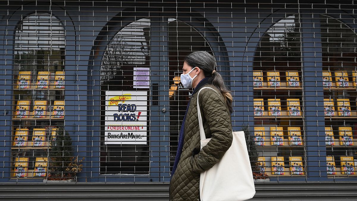 A woman walks by the closed "Books Are Magic" bookstore on May 5, 2020 in the Brooklyn borough of New York City. (Photo by Angela Weiss / AFP)