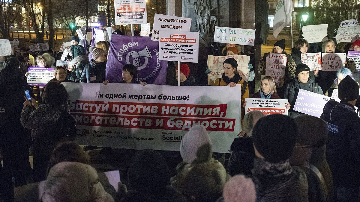 People hold banners against domestic violence attend a rally in Moscow's downtown, R on Monday, Nov. 25, 2019.ussia
