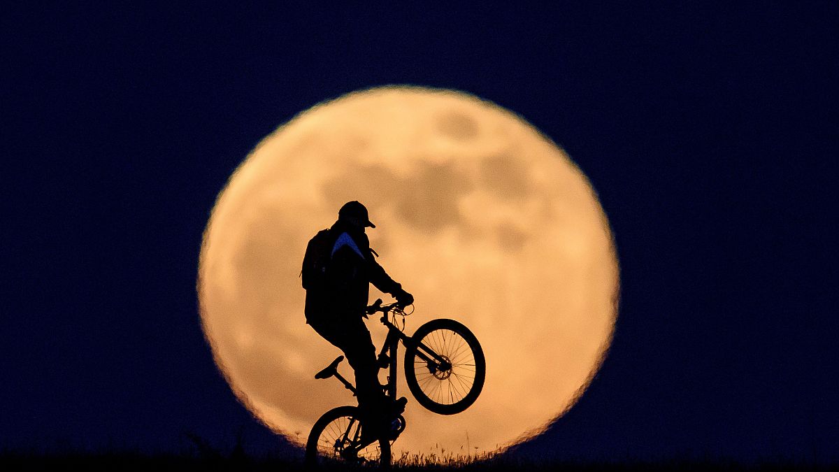 Kerékpáros a felkelő Hold előtt Salgótarján közelében 2020. május 7-én