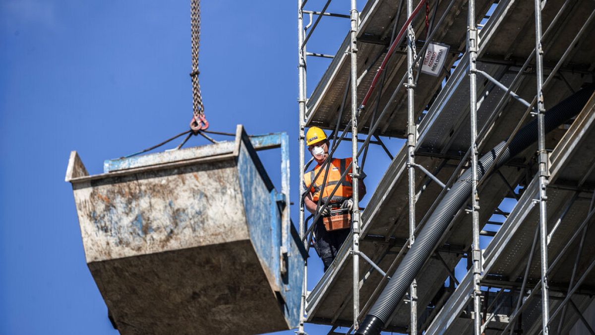 A worker operates at a construction site in Milan, Italy, Thursday, May 7, 2020.