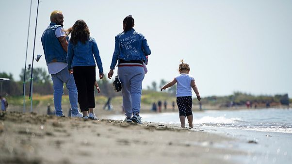 People walk along the beach of Ladispoli, a coastal town some 30 kilometers (18 miles) north of Rome, Saturday, May 9, 2020. People walk along the beach of Ladispoli, a coastal town some 30 kilometers (18 miles) north of Rome, Saturday, May 9, 2020.