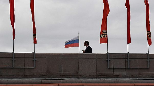 A man walks on a bridge past red banners devoted to the 75th anniversary of the victory over Nazi Germany during World War II, in downtown Moscow on May 9, 2020 A man walks on a bridge past red banners devoted to the 75th anniversary of the victory over Nazi Germany during World War II, in downtown Moscow on May 9, 2020