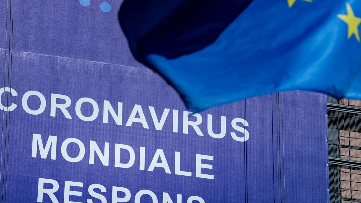 An European Union (EU) flag flutters in front of a newly hung banner that reads "Coronavirus Global Response" in front of The EU Commission building in Brussels. May 6, 2020