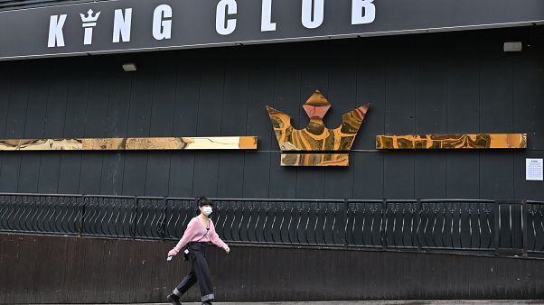 A woman wearing a face mask walks past a night club,on May 10, 2020. - South Korea A woman wearing a face mask walks past a night club,on May 10, 2020. - South Korea