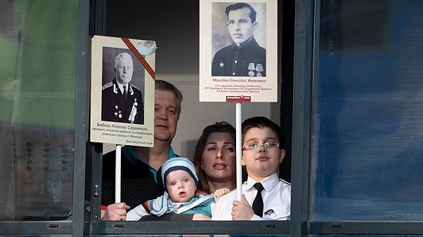 Ermakov's family who cannot go outside to celebrate Victory Day due to coronavirus hold portraits of their ancestors.