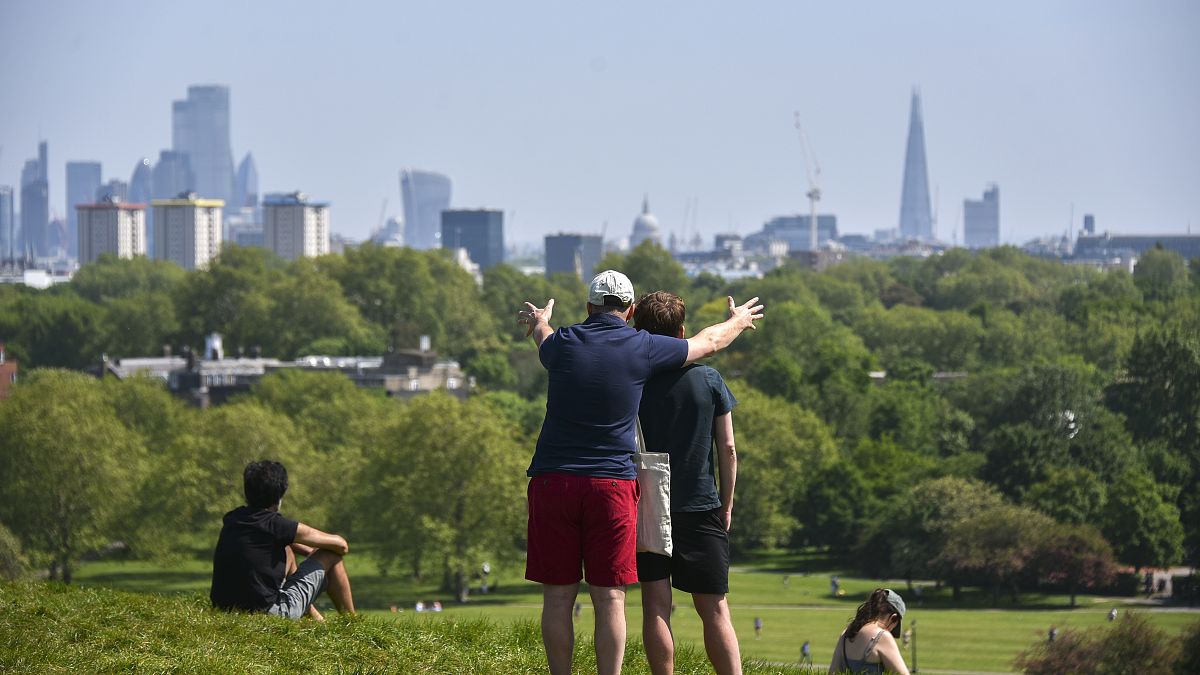 People enjoy the warm weather at Primrose Hill, as Britain faces its seventh week of lockdown due to the coronavirus outbreak, in London, Saturday, May 9, 2020. 