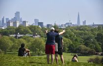 People enjoy the warm weather at Primrose Hill, as Britain faces its seventh week of lockdown due to the coronavirus outbreak, in London, Saturday, May 9, 2020. 