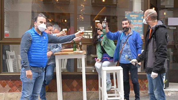 Un grupo de amigos bebe cerveza en un bar tras su reencuentro Un grupo de amigos bebe cerveza en un bar tras su reencuentro