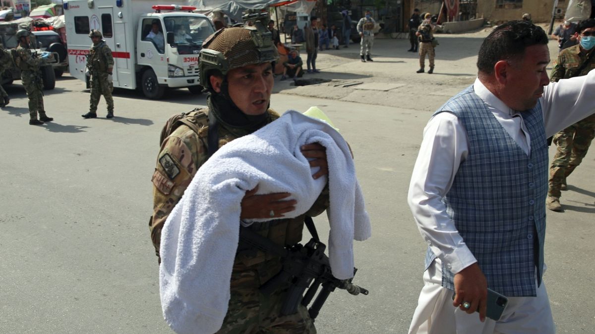 Afganistanlı asker Kabil'in batısında yaşanan hastane saldırısı sonrası bir bebeği taşıyor