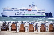 EIn Strand in Warnemünde bei Rostock: Im Hintergrund eine Fähre auf dem Weg nach Dänemark