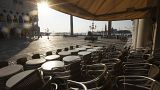 In this Monday, April 6, 2020 file photo, chairs and tables are piled in front of a bar in St. Mark's Square, in Venice during a lockdown to prevent the spread of COVID-19
