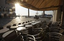 In this Monday, April 6, 2020 file photo, chairs and tables are piled in front of a bar in St. Mark's Square, in Venice during a lockdown to prevent the spread of COVID-19