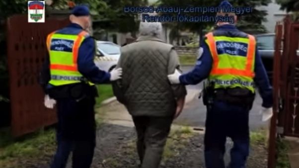 Uno dei due uomini accusati di procurato allarme portato via dalla polizia Uno dei due uomini accusati di procurato allarme portato via dalla polizia