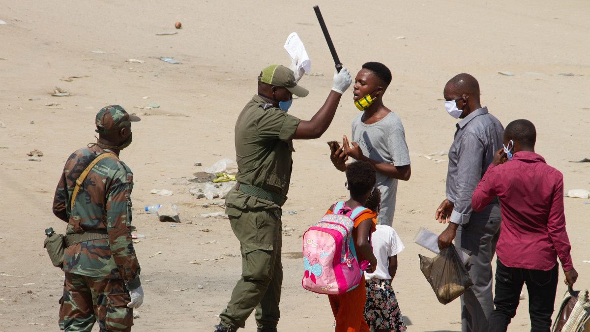 Um agente de autoridade interpela um jovem no distrito de Kifangondo, em Luanda
