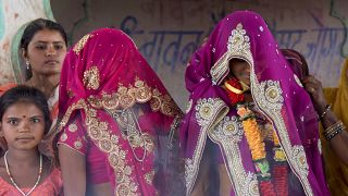 عروس قاصر تقف مع أفراد أسرتها أثناء زواجها في معبد هندوسي بالقرب من راجاره، ولاية ماديا براديش، الهند. 2017/04/17