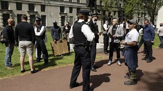 Police officers speak to people taking part in a coronavirus anti-lockdown, anti-vaccine, anti-5G and pro-freedom protest in London on May 2, 2020.