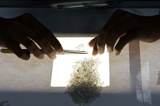 A worker sorts diamonds according their color (AP Photo/Themba Hadebe)