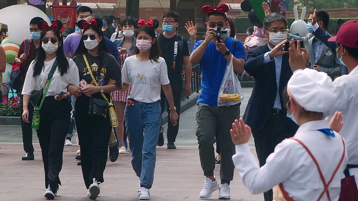 زائرون يرتدون أقنعة يدخلون حديقة ديزني في شنغهاي الذي أعاد فتح أبوابه - 2020/05/11