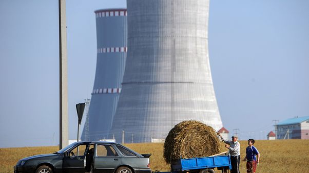 A pictureshows people transporting a bundle of straw close to the construction site of the first Belarus' nuclear power plant outside the town of Ostrovets A pictureshows people transporting a bundle of straw close to the construction site of the first Belarus' nuclear power plant outside the town of Ostrovets
