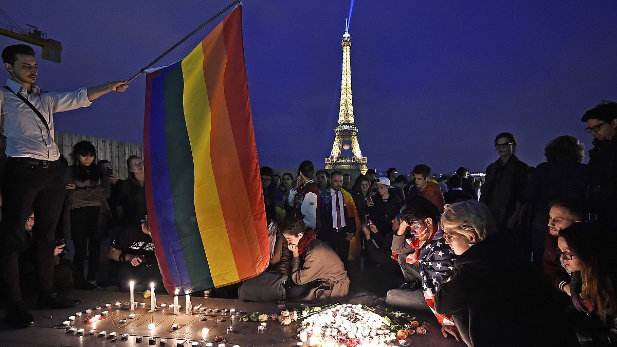 People in Paris pay tribute the victims of a mass shooting at an Orlando gay club, Monday, June 13, 2016. 