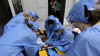 File photo-Medical workers wearing special suits to protect against coronavirus, conduct testing for COVID-19