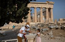 Visitors wash their hands in front of ancient Parthenon temple at the Acropolis hill of Athens, on Monday, May 18, 2020.