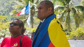 A man and a woman line up to cast their votes at a polling station in Nouméa, New Caledonia, as part of the independence referendum - November 4, 2018 