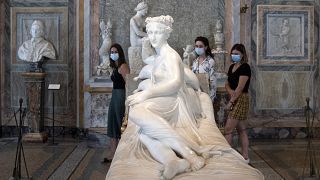 Visitors wearing a face mask view "Paolina Borghese Bonaparte as Venus Victrix", by Antonio Canova at the Galleria Borghese