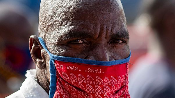 Um homem proteje-se da epidemia em Tembisa, Joanesburgo, África do Sul Um homem proteje-se da epidemia em Tembisa, Joanesburgo, África do Sul