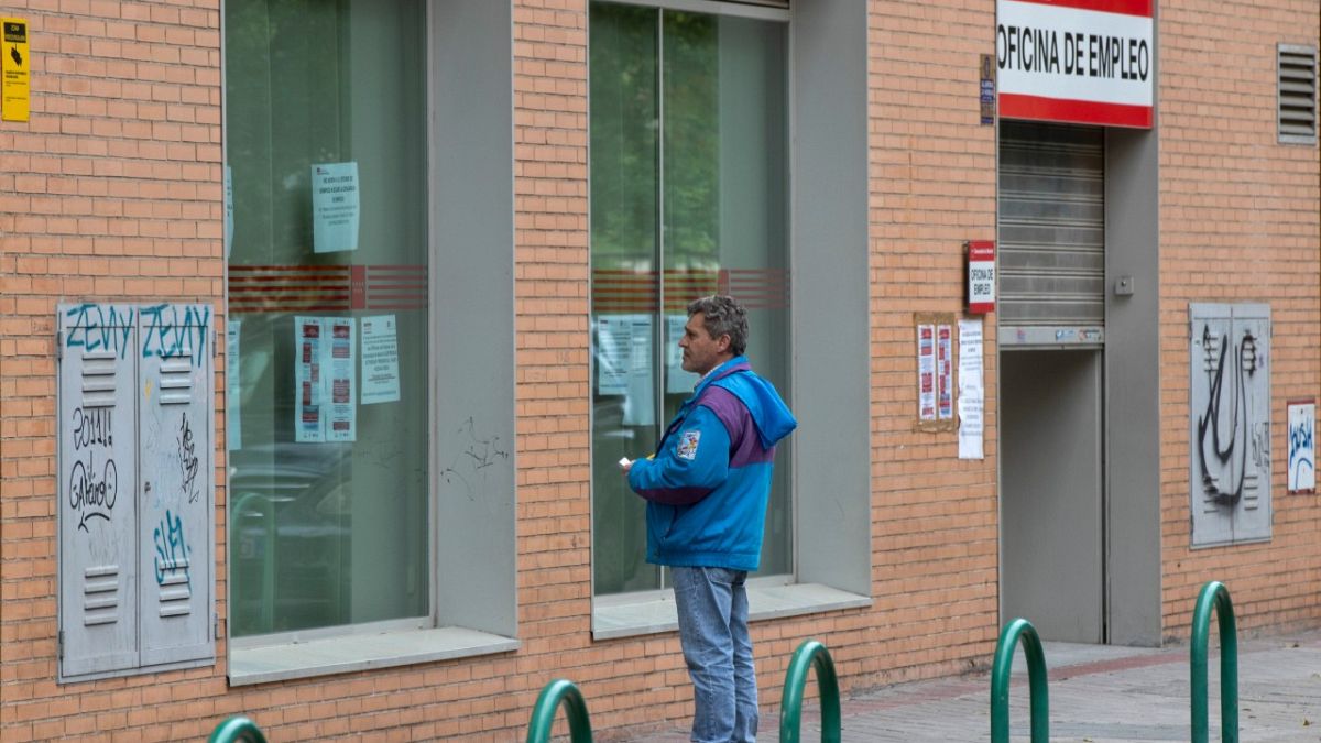 Un homme regarde des annonces d'emploi sur la vitrine d'une agence pour l'emploi à Madrid en Espagne