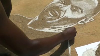 Он рисует футболистов на песке