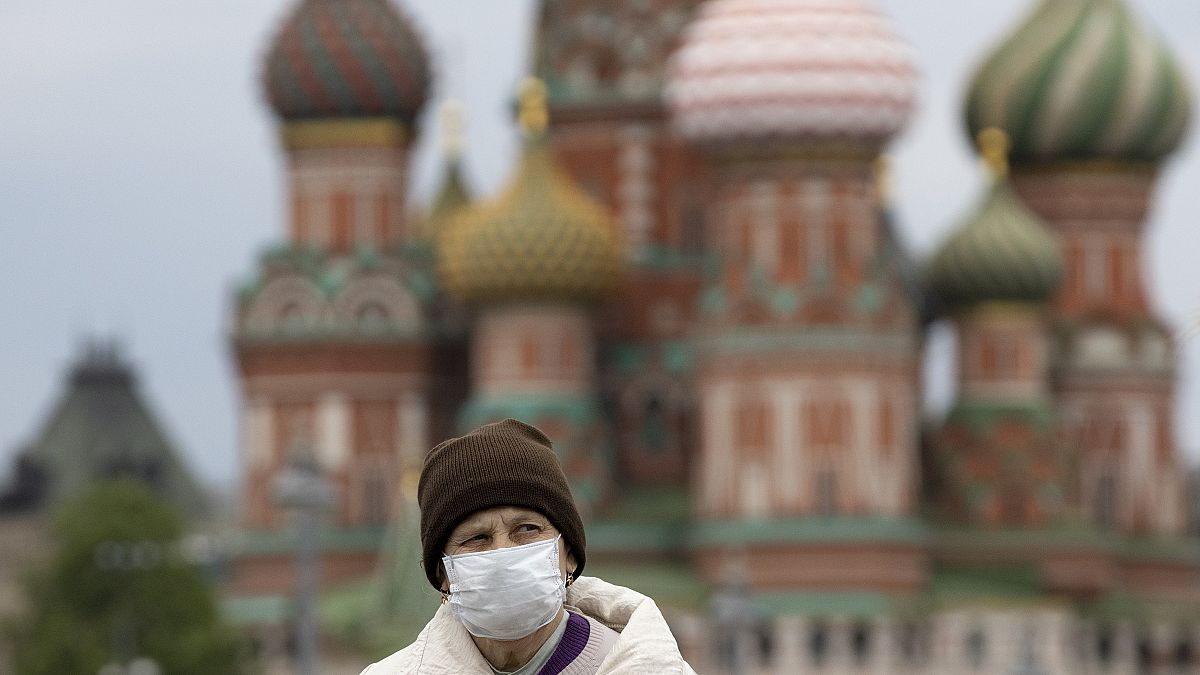 Moskova'daki Kızıl Meydan'da koronavirüsten dolayı maskesiyle yürüyen bir vatandaş
