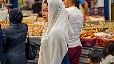 شابة سورية تسير وسط السوق المركزي في القامشلي بمحافظة الحسكة. 19/05/2020