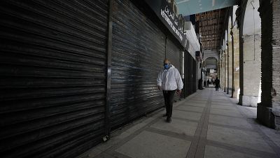 رجل يمشي قرب محلات تجارية في العاصمة الجزائر - 2020/04/29