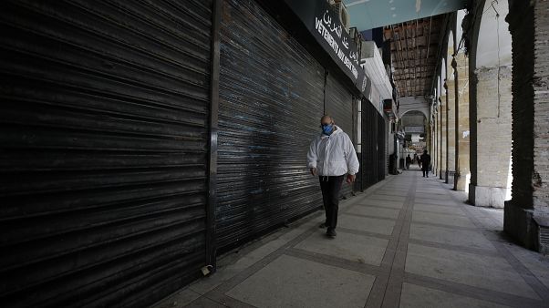 رجل يمشي قرب محلات تجارية في العاصمة الجزائر - 2020/04/29 رجل يمشي قرب محلات تجارية في العاصمة الجزائر - 2020/04/29