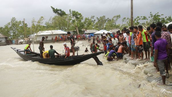 A boat brings people to land, as locals check an embankment before Cyclone Amphan made landfall, in Shyamnagar, Shatkhira, Bangladesh. A boat brings people to land, as locals check an embankment before Cyclone Amphan made landfall, in Shyamnagar, Shatkhira, Bangladesh.