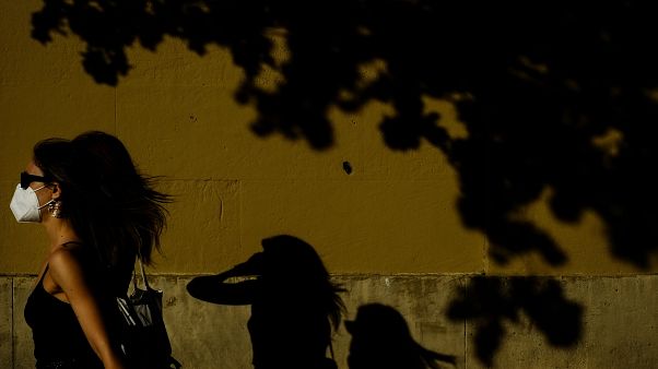 Una mujer camina con mascarilla por una calle de Pamplona Una mujer camina con mascarilla por una calle de Pamplona