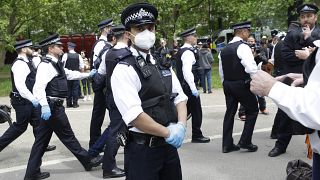 A police officer wears a face mask during a mass gathering protest organised by the group called 'UK Freedom Movement', in Hyde Park in London