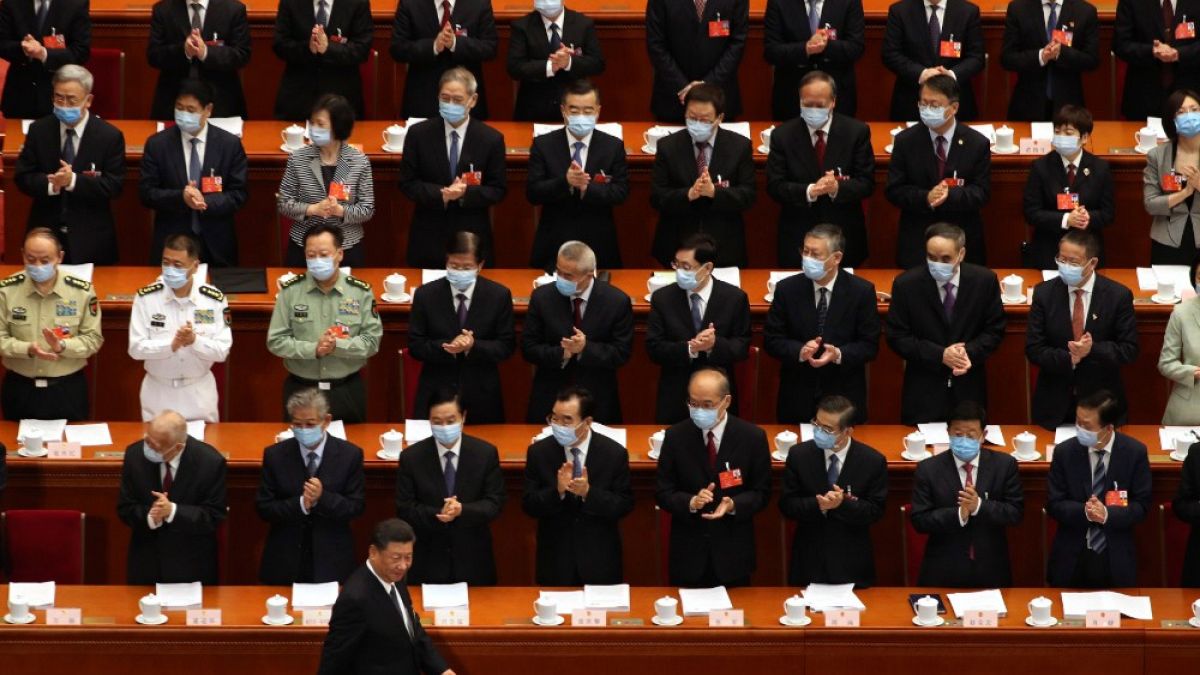I delegati applaudono l'arrivo del Presidente Xi Jinping al Congresso Nazionale del Popolo cinese, a Pechino