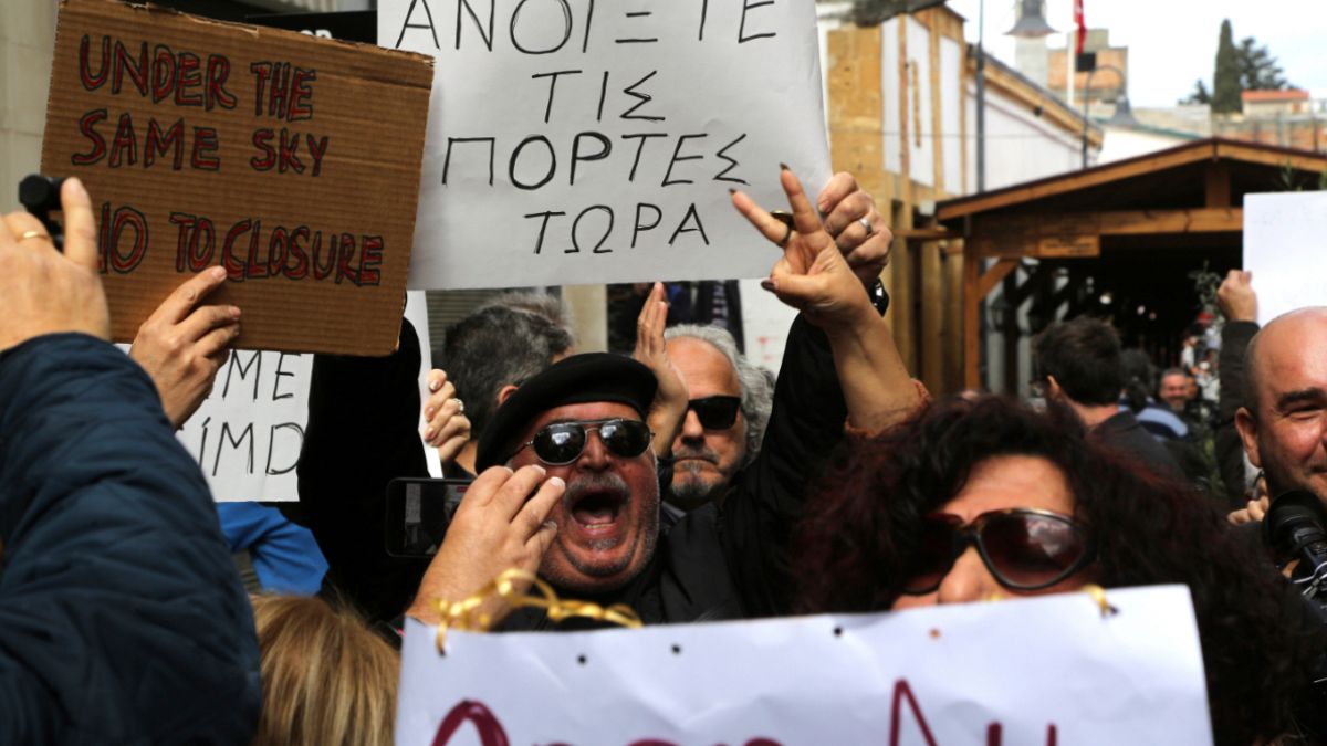 متظاهرون يطالبون بفتح نقطة عبور بين شطري قبرص، حاملين لافتات كتب عليها باليونانية "افتح الأبواب الآن" 29/02/2020