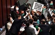 Hong Kong pro-democracy lawmakers holding up placards are blocked by security as they protest during a meeting chaired by pro-Beijing lawmakers on May 22, 2020