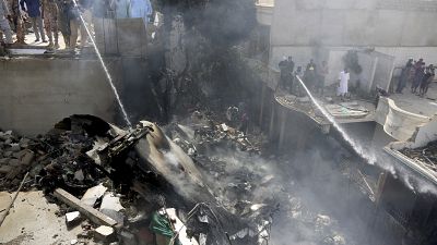 Des pompiers finissent d'éteindre l'incendie provoqué par la chute d'un avion sur Karachi - Pakistan - le 22 mai 2020