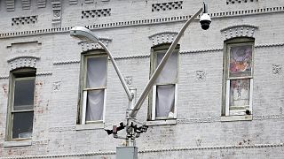 A surveillance camera, top right, and license plate scanners, center, are seen at an intersection in West Baltimore