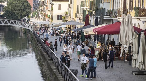 People walk along the Naviglio grande canal in Milan, Italy, Monday, May 18, 2020 People walk along the Naviglio grande canal in Milan, Italy, Monday, May 18, 2020