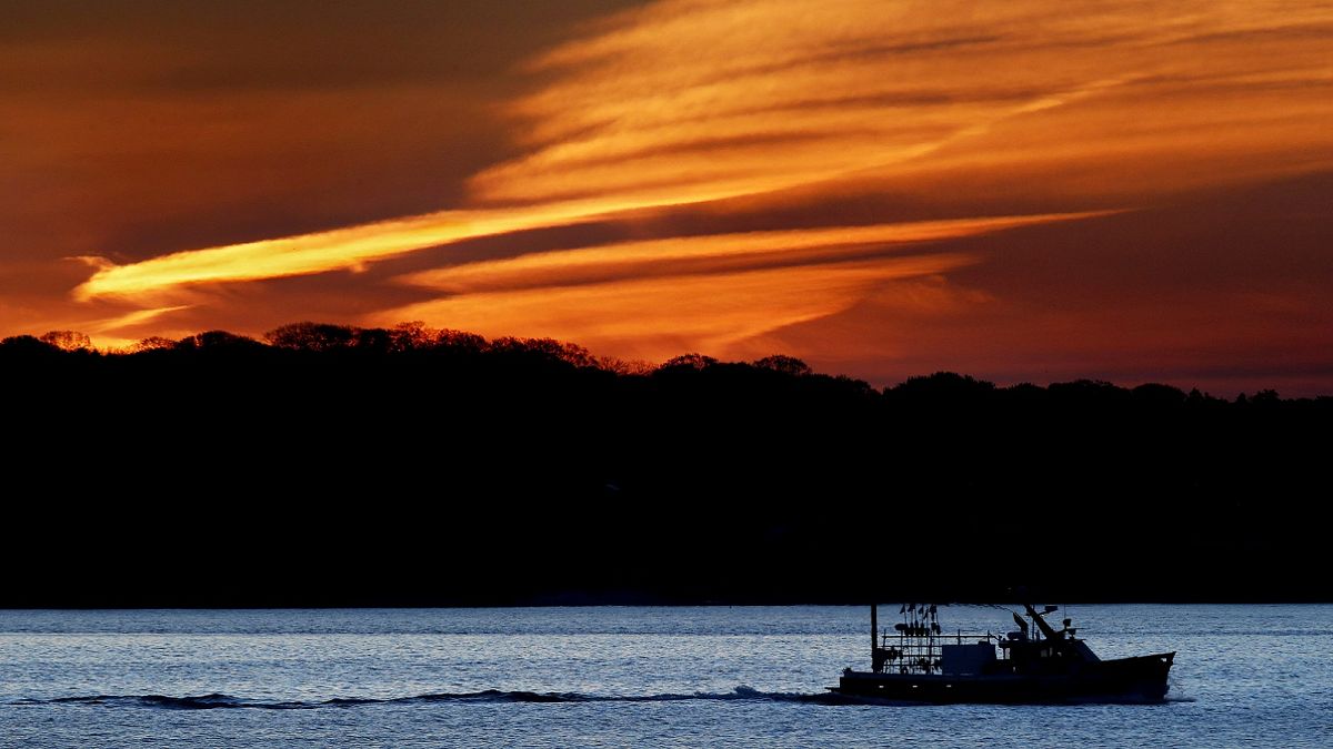The lobster boat Deborah & Megan II motors out to sea at dawn, Thursday, May 21, 2020, off South Portland, Maine