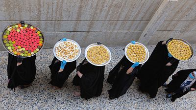 سيدات عراقيات يحملن على رؤوسهن بمدينة البصرة حلوى عيد الفطر الموافق ليوم غد الأحد 22/05/2020