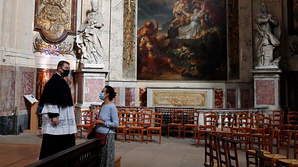 Un prêtre parle avec une croyante avant une message en l'église Saint Roch à Paris, le 23 mai 2020 Un prêtre parle avec une croyante avant une message en l'église Saint Roch à Paris, le 23 mai 2020