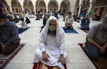 Musulmanes con máscaras faciales asisten a las oraciones de Eid al-Fitr fuera de una mezquita en la ciudad de Gaza, el 24 de mayo de 2020.