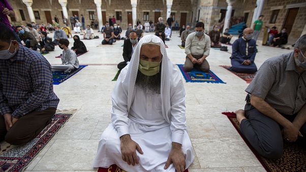 Musulmanes con máscaras faciales asisten a las oraciones de Eid al-Fitr fuera de una mezquita en la ciudad de Gaza, el 24 de mayo de 2020. Musulmanes con máscaras faciales asisten a las oraciones de Eid al-Fitr fuera de una mezquita en la ciudad de Gaza, el 24 de mayo de 2020.